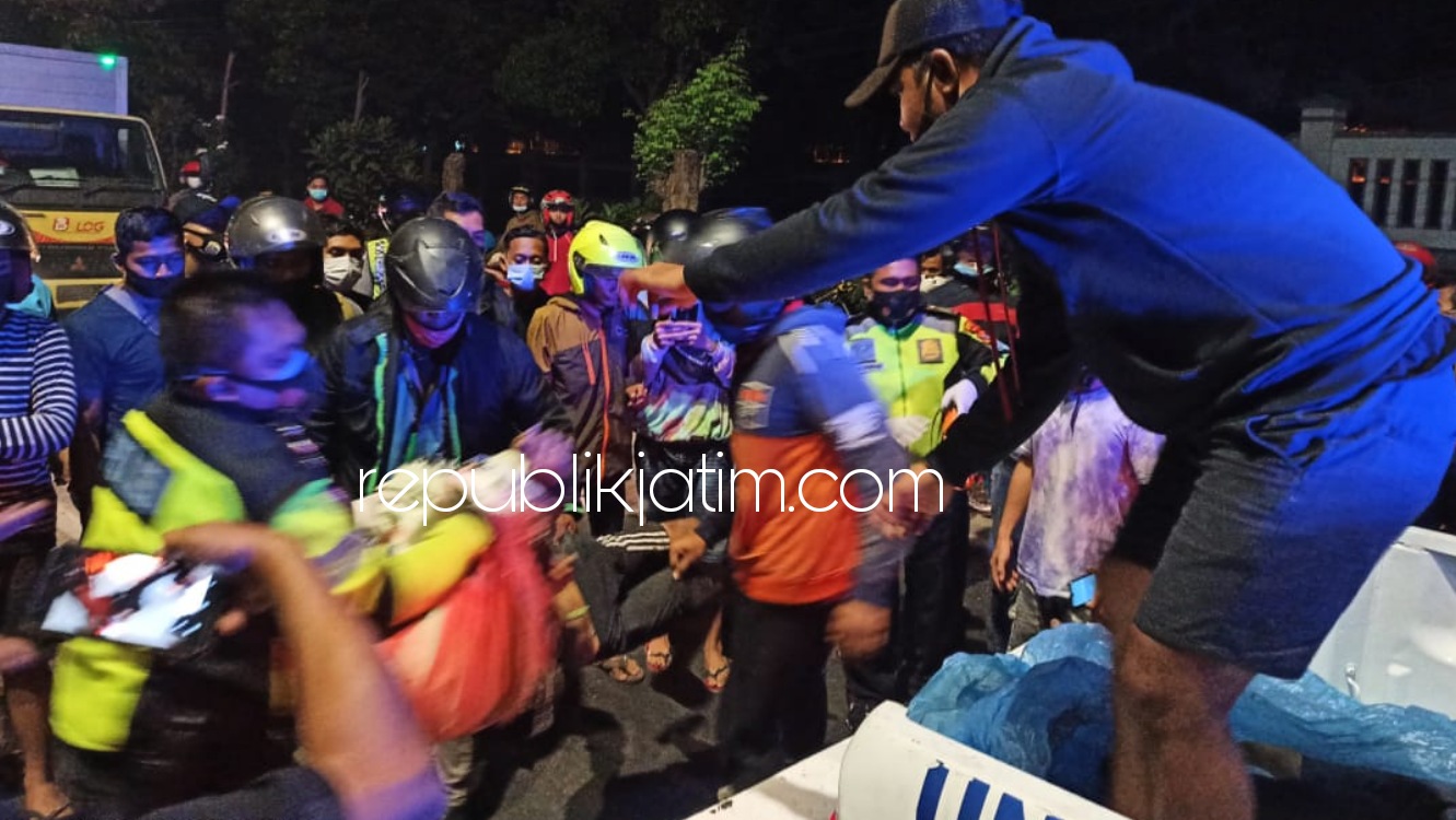EVAKUASI - Sejumlah petugas mengevakuasi dua korban tewas dalam kecelakaan tabrakan antar motor di JL Raya A Yani depan Pasmar Gedangan, Sidoarjo, Minggu (18/10/2020) dini hari. 