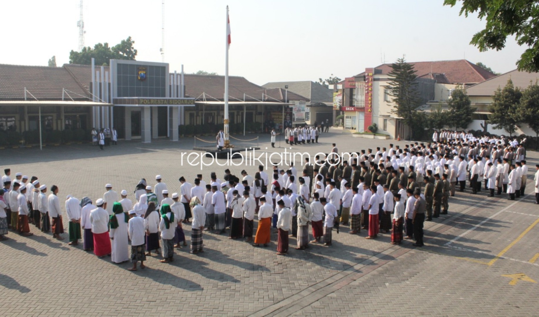 SARUNG - Anggota Polresta Sidoarjo, TNI dan santri menggunakan sarung, peci dan surban saat upacara Hari Santri Nasional 2019 di halaman Polresta Sidoarjo, Selasa (22/10/2019).