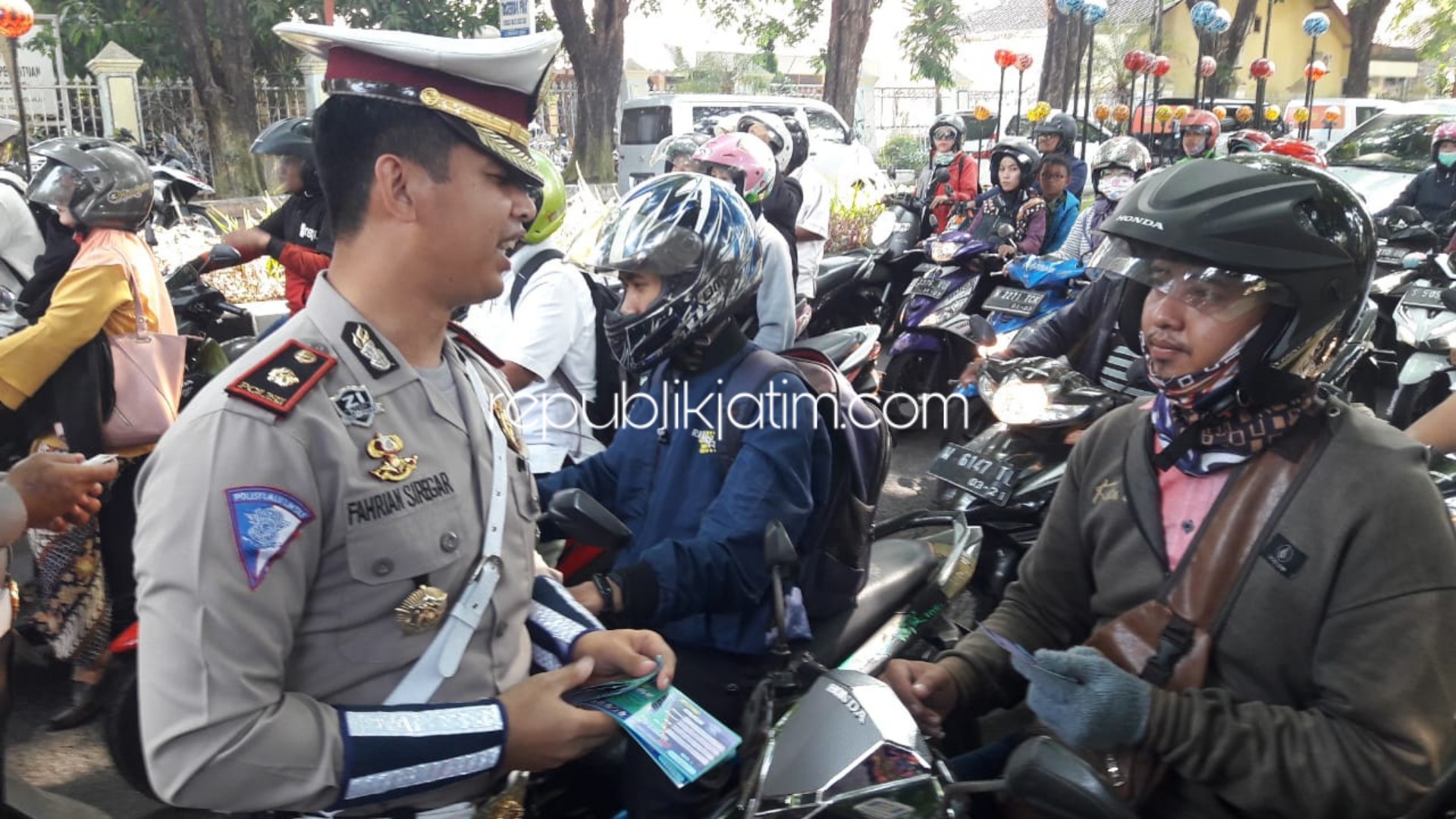 KUPON - Kasat Lantas, Polresta Sidoarjo, Kompol Fahrian Saleh Siregar membagikan 20.000 kupon undian motor untuk para pengendara yang tertib saat Operasi Zebra di Paseban Alun-Alun Sidoarjo, Rabu (23/10/2019).