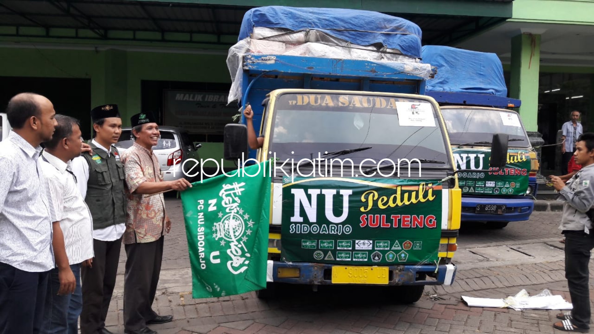BERANGKATKAN - Wakil Sekretaris PCNU Sidoarjo, M Zaenal Arifin dan Direktur NU Care Lazisnu Sidoarjo, Dodi Dyauddin memberangkatkan 4 truk logistik dan uang Rp 380 juta untuk korban tsunami Palu, Donggala dan Sigi Sulteng, Kamis (25/10/2018).