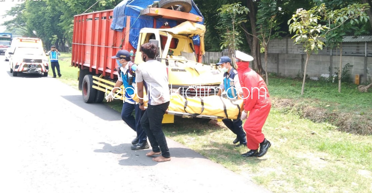 EVAKUASI - Sejumlah petugas mengevakuasi jenazah sopir truk, Sugiyanto (41) warga Desa Kertasada, Kecamatan Kalianget, Sumenep, Madura di JL Raya Tol Sidoarjo - Porong, Desa Sepande, Kecamatan Candi, Sidoarjo, Senin (26/10/2020).
