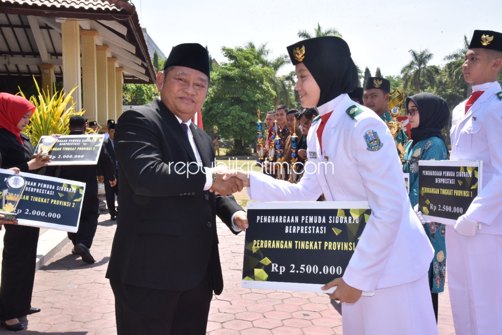PENGHARGAAN - Bupati Sidoarjo, Saiful Ilah memberikan penghargaan kepada sejumlah pemuda Sidoarjo atas prestasinya usai Upacara Peringatan Hari Sumpah Pemuda ke 91, di Alun-Alun Sidoarjo, Senin (28/10/2019).