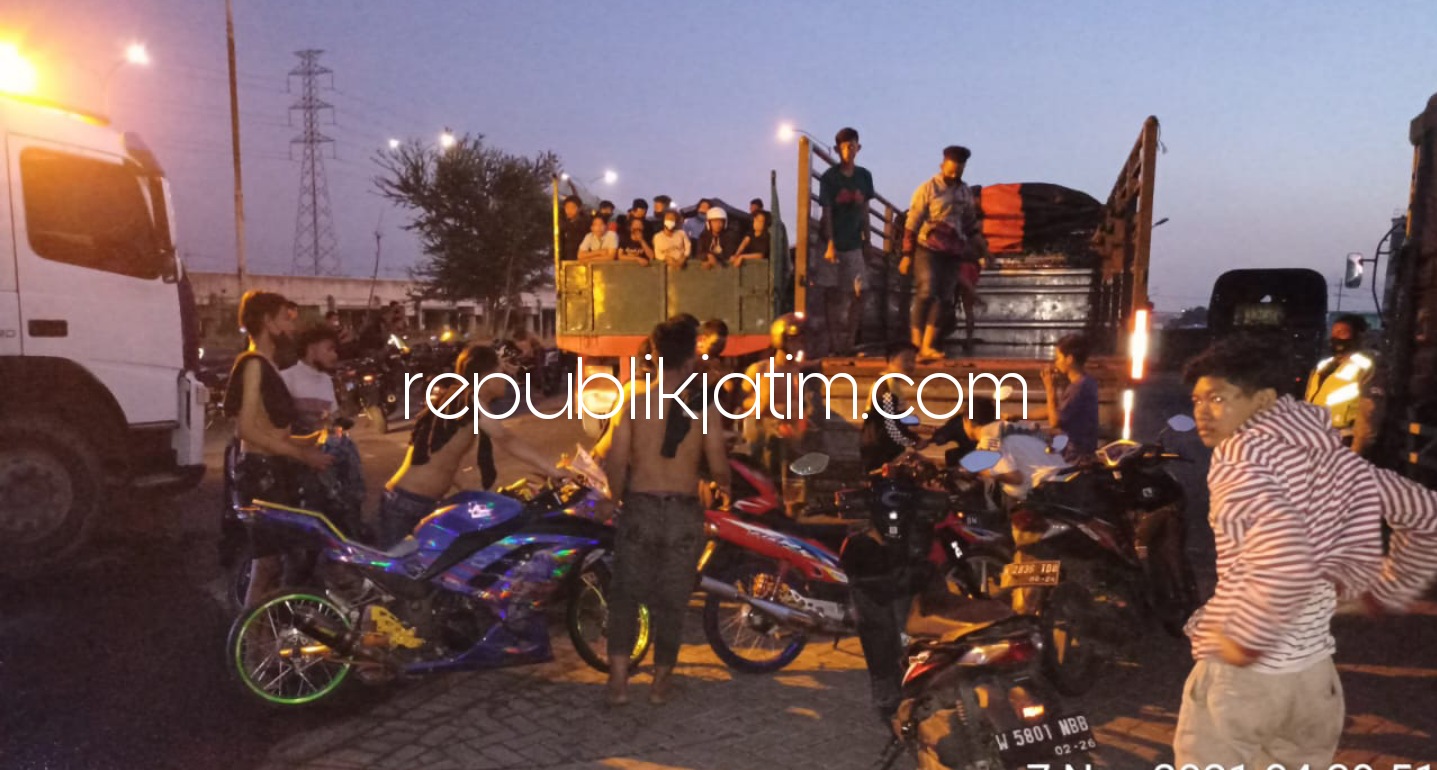 ANGKUT - Ratusan motor beserta joki balap liar diamankan dan diangkut petugas gabungan Satuan Lantas dan Reskrim Polresta Sidoarjo saat razia balap liar di JL Raya Arteri Porong, Sidoarjo, Minggu (07/11/2021) dini hari.