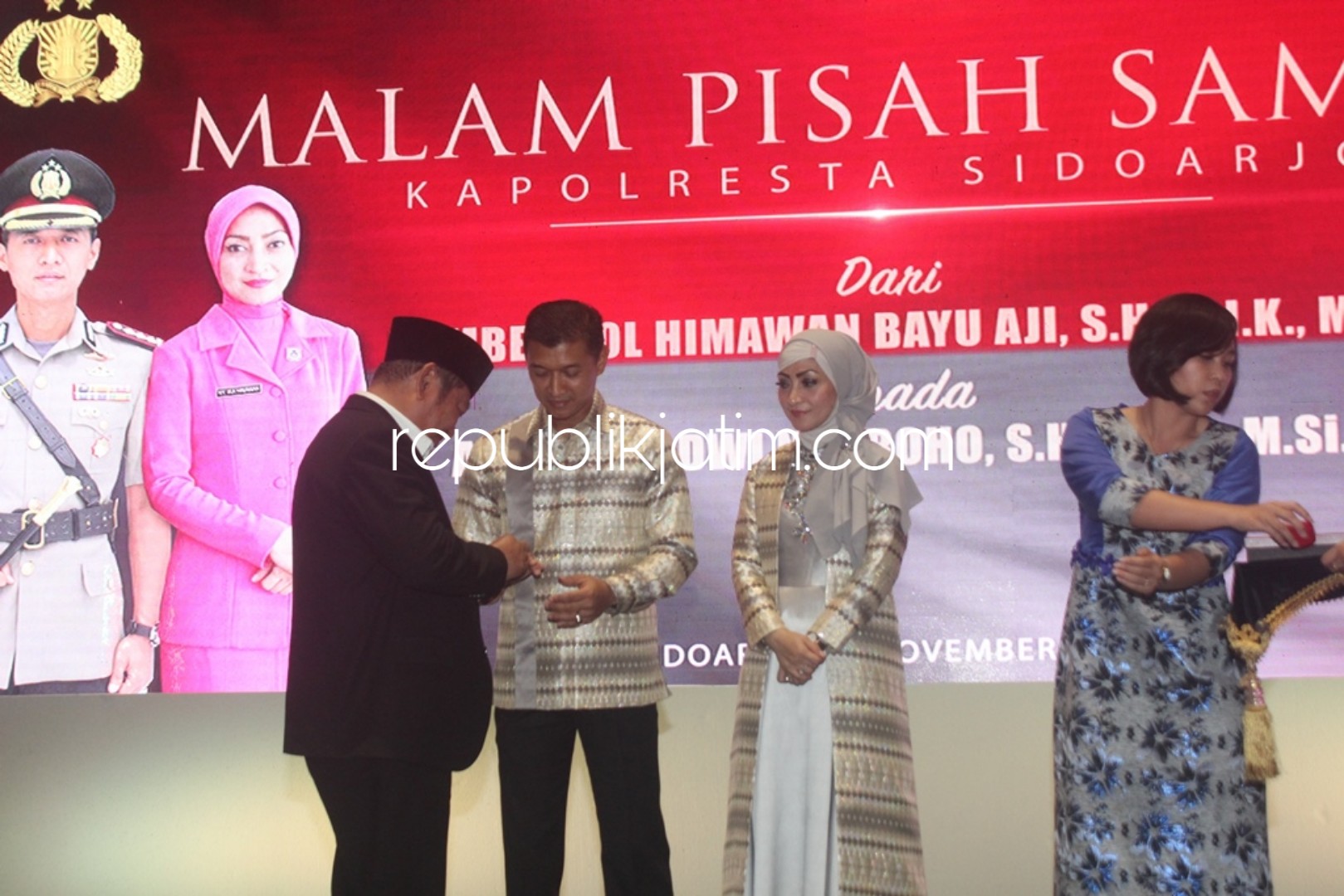 CINDERA MATA - Bupati Sidoarjo, Saiful Ilah memberikan cinderamata ke mantan Kapolresta Sidoarjo, Kombes Pol Himawan Bayu Aji dalam acara pisah sambut di gedung SCC, Sabtu (10/11/2018) malam.
