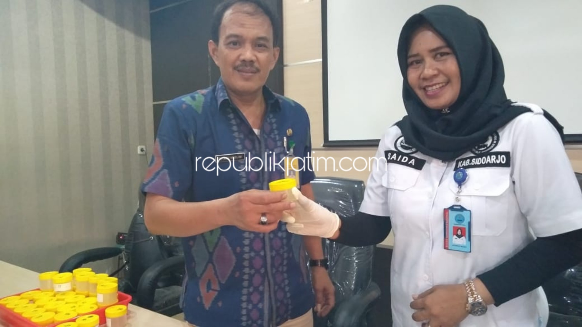 TES URINE - Camat Jabon, M Aziz Muslim dan Kasi P2M BNN Sidoarjo, AKP Siti Saida saat menyerahkan urine dalam botol yang bakal dites, Kamis (14/11/2019).