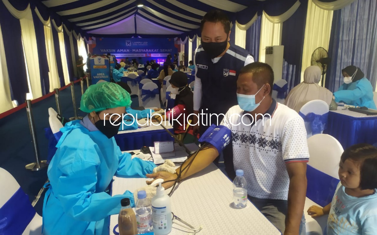 VAKSIN - Direktur PT Sarana Karya Solusindo produsen lampu merek Bandell, Reza Kurniawan menemani para Nakes yang melayani vaksin kedua 600 warga di Perum Puri Surya Jaya Gedangan, Sidoarjo, Minggu (14/11/2021).