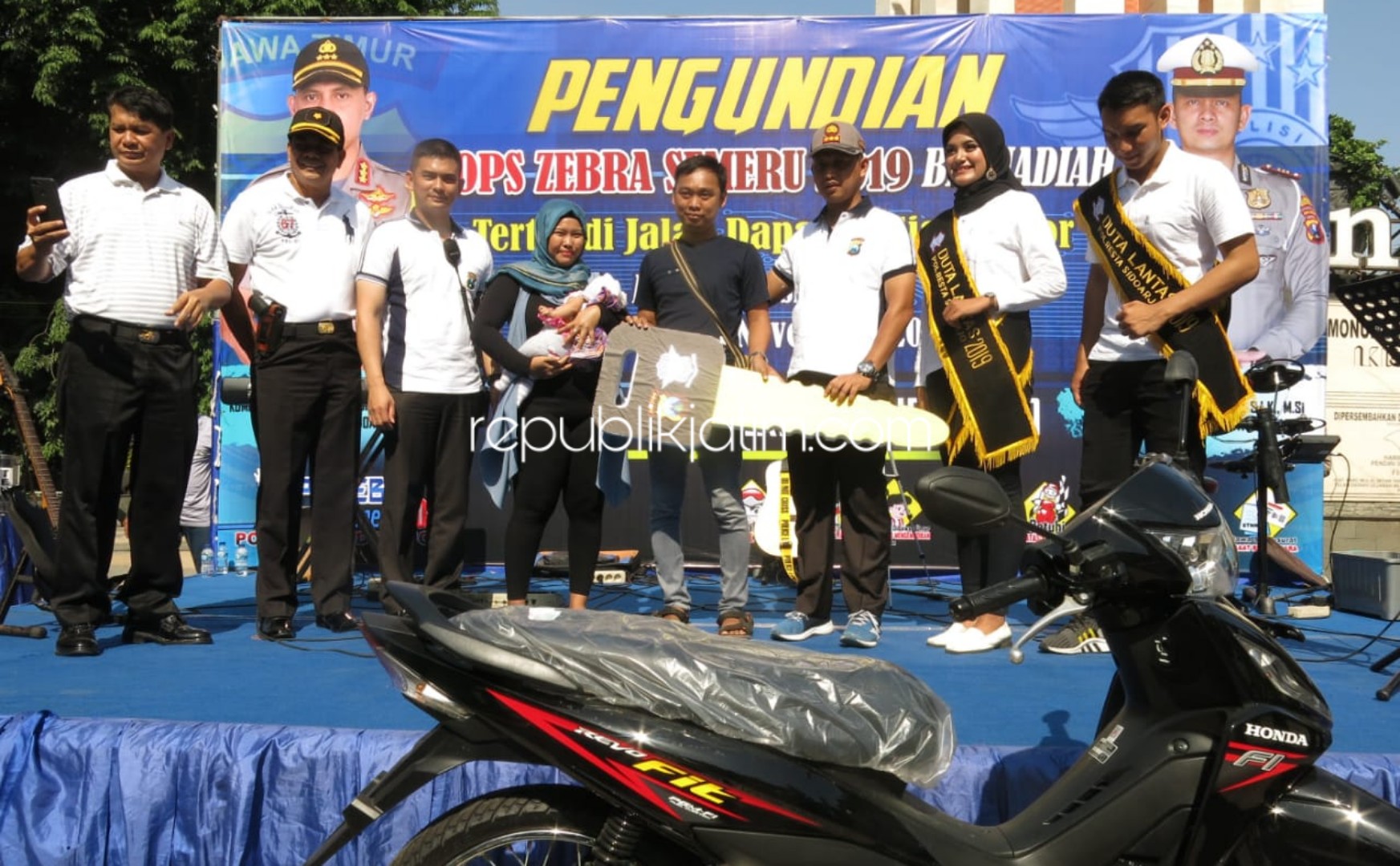 HADIAH - Kapolresta Sidoarjo, Kombes Pol Zain Dwi Nugroho menyerahkan hadiah sepeda motor undian kupon tertib lalu lintas di Monumen Jayandaru, Alun-Alun Sidoarjo kepada M Syafi'i warga Desa Ngampelsari, Kecamatan Candi, Sidoarjo, Minggu (17/11/2019).