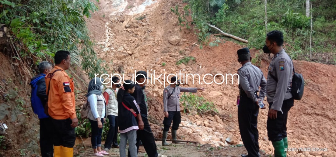 LONGSOR - Petugas Polsek, Koramil dan Pemdes serta warga Desa Tugurejo, Kecamatan Slahung, Ponorogo saat membersihkan material longsor yang menutup badan jalan, Sabtu (20/11/2021).