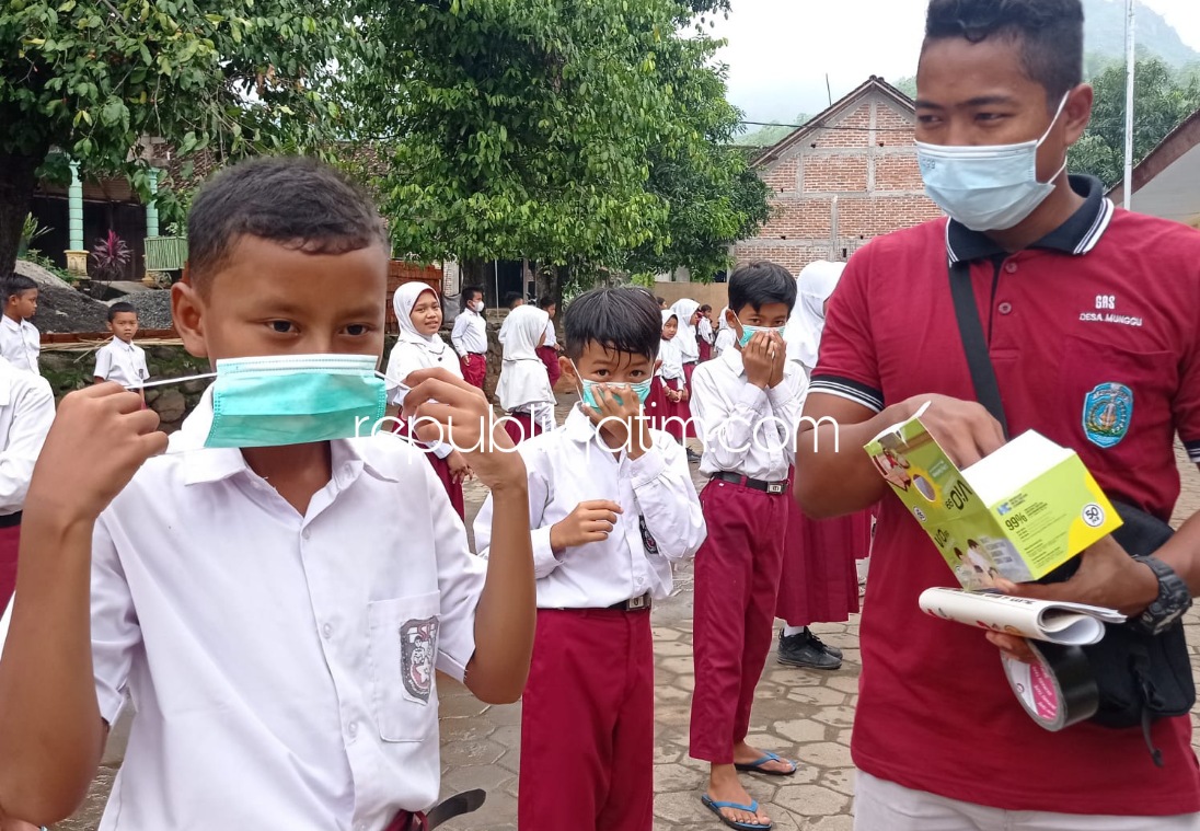 BAGI MASKER - Pemdes dan Satgas Desa Munggu, Kecamatan Bungkal, Ponorogo membagikan masker dan sosialisasi di pasar dan sekolah soal protokol kesehatan, Selasa (23/11/2021). 