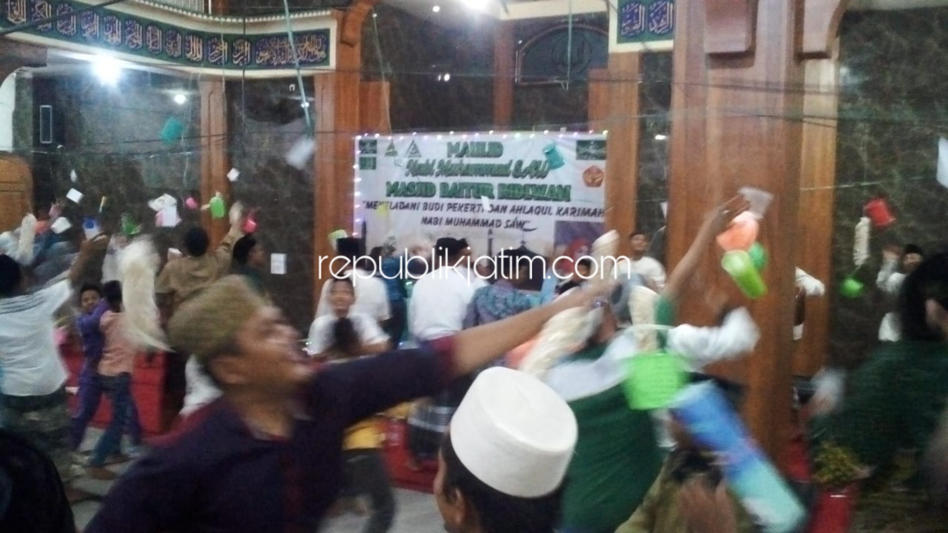 REBUTAN - Sejumlah jamaah berebut ratusan door prize (hadiah) saat memperingati Maulid Nabi Muhammad SAW di Masjid Baitur Ridwan Desa Penambangan, Kecamatan Balongbendo, Sidoarjo, Minggu (24/11/2019) malam.