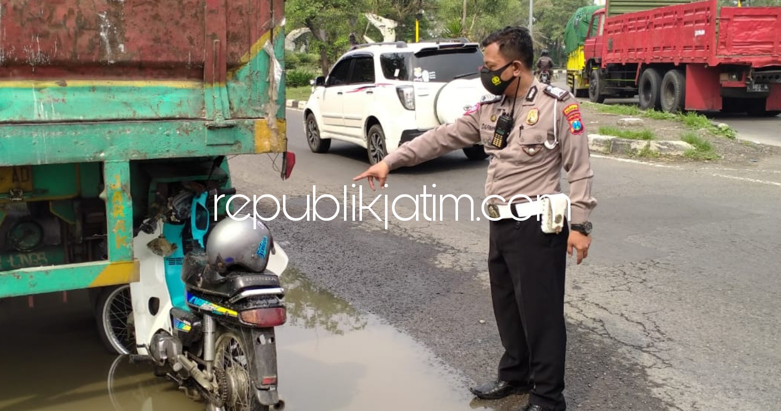 EVAKUASI - Petugas Unit Lantas Polsek Krian mengevakuasi dan menggelar olah TKP di jalur Surabaya-Mojokerto (Krian) seusai motor korban menabrak truk Fuso parkir, Kamis (26/11/2020).