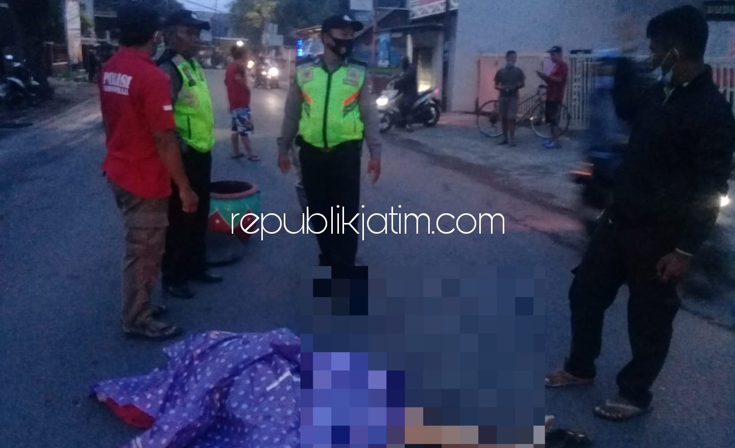 EVAKUASI - Petugas Polsek Sukodono mengevakuasi jenazah pria yang jatuh dari motor Honda Beat bernopol W 6851 OF di JL Raya Depan Puskesmas Sukodono, Sidoarjo, Senin (30/11/2020).