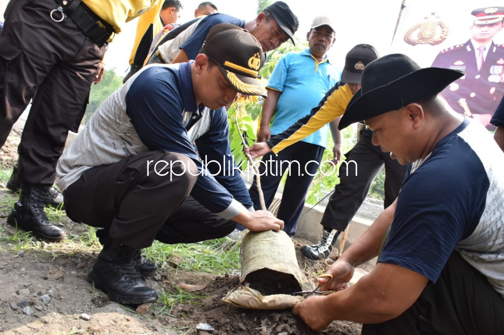 TANAM POHON - Kapolresta Sidoarjo, AKBP Zain Dwi Nugroho menanam pohon bersama kaum disabilitas, Mulyono di Desa Sidomojo, Kecamatan Krian, Sidoarjo, Jumat (07/12/2018).