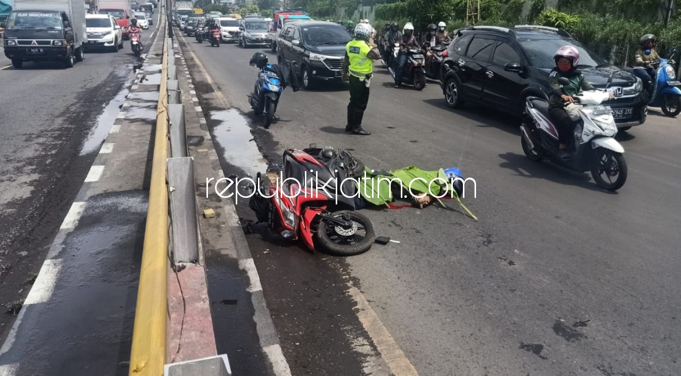 EVAKUASI - Petugas Unit Laka, Satuan Lantas, Polresta Sidoarjo mengevakuasi jenazah korban kecelakaan Hendri Susanto (41) pengendara motor Honda bernopol L 6456 ZR di JL Raya Waru, Kecamatan Waru, Sidoarjo, Senin (07/12/2020).