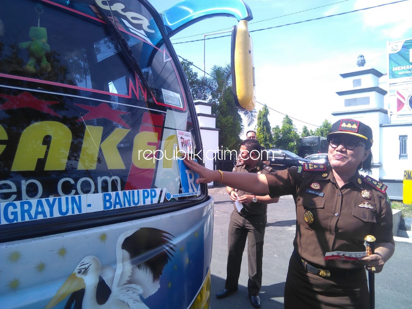 TEMPEL STIKER - Kepala Kejari Ponorogo, Indah Laila membagi dan menempel stiker ajakan cegah korupsi sejak dini ke sejumlah kendaraan yang melintas sebagai Peringatan Hari Anti Korupsi, Senin (09/12/2019).