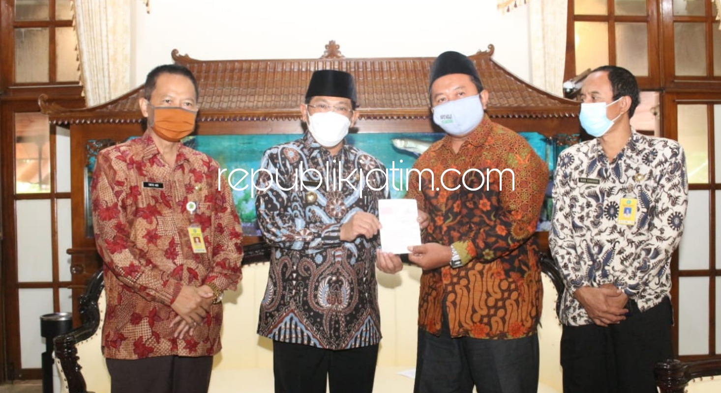 SERAHKAN - Pj Bupati Sidoarjo, Hudiyono menyerahkan secara simbolis buku rekening tabungan bantuan makanan kepada salah satu pengurus panti asuhan yatim piatu di Pendopo Delta Wibawa, Kamis (10/12/2020).