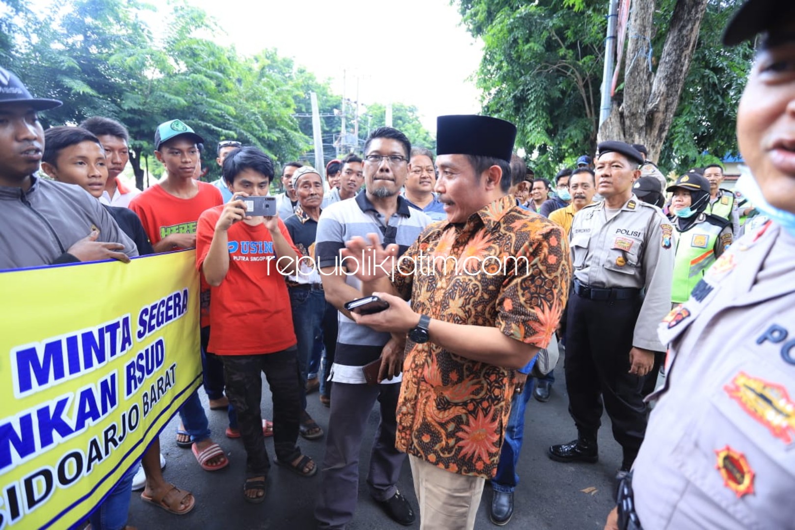 DESAK PEMBANGUNAN - Ketua Komisi D DPRD Sidoarjo, M Dhamroni Cudlori menemui puluhan pendemo asal Kecamatan Tarik dan Kecamatan Bendo yang mendesak pembangunan RSUD Barat di depan Kantor DPRD Sidoarjo, Kamis (12/12/2019).