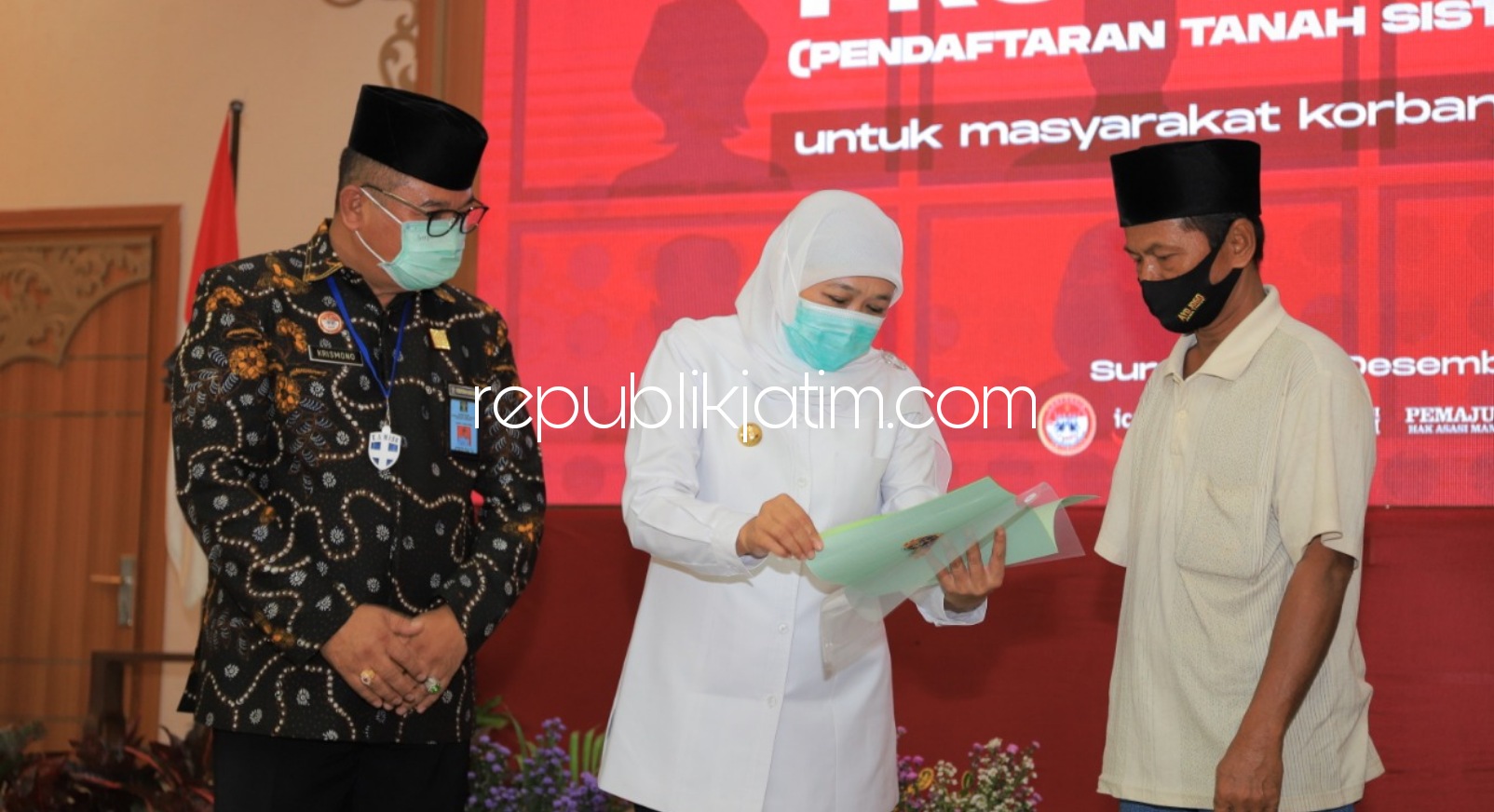 SERAHKAN - Gubernur Jatim, Khofifah Indar Parawansa menyerahkan sertifikat kepada warga Sampang (Madura) yang tinggal di Rusunawa Jemundo, Kecamatan Taman, Sidoarjo didampingi Kepala Kanwil Kemenkumham, Krismono, Senin (14/12/2020).