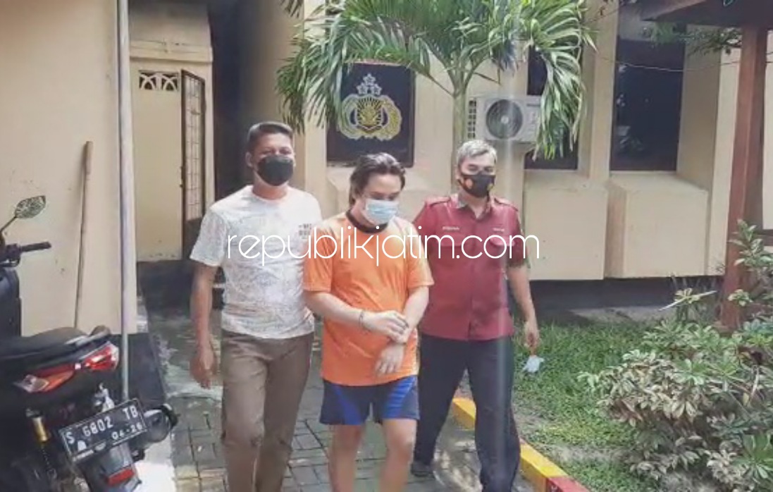 DITANGKAP - Mucikari waria Bella Aristha warga Mojosari, Kabupaten Mojokerto saat digelandang petugas Satuan Reskrim Polres Mojokerto untuk ditahan, Selasa (14/12/2021).