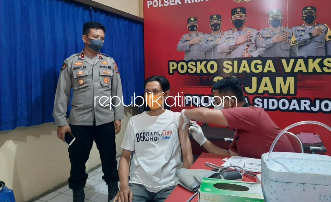 VAKSIN - Kapolsek Krian, Kompol Gatot Setyabudi saat memantau Saiful Arif warga Desa Jeruklegi, Kecamatan Balongbendo yang divaksin Sinovac dosis 2 di Polsek Krian, Jumat (17/12/2021).