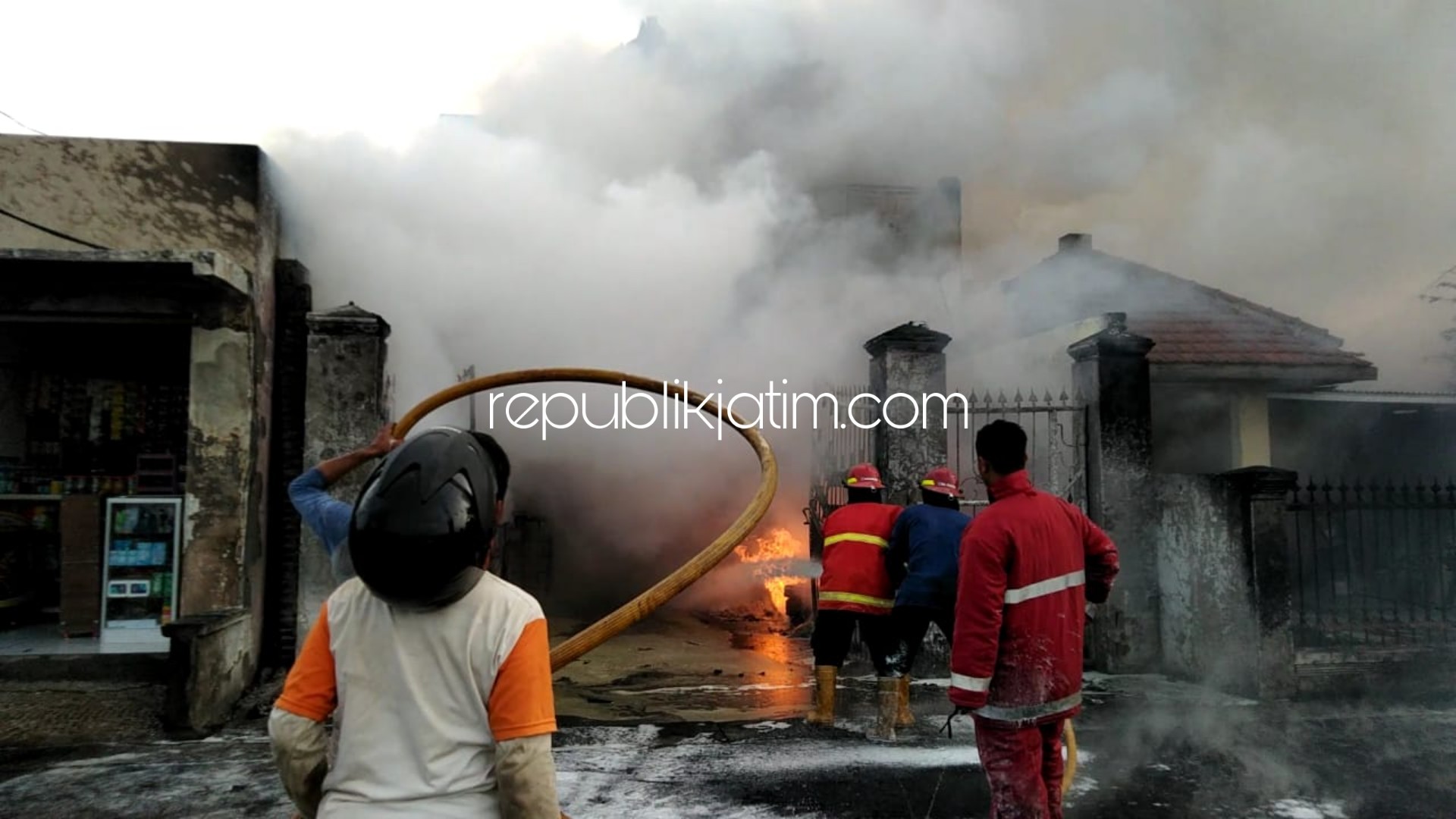 TERBAKAR - Sejumlah petugas PMK berusaha memadamkan api yang membakar rumah dua lantai milik H Kholidin di Dusun Kedunganten, Desa Kalitengah, Kecamatan Tanggulangin, Sidoarjo yang disewa pekerja proyek Jl Raya Kludan, Rabu (18/12/2019) sore.