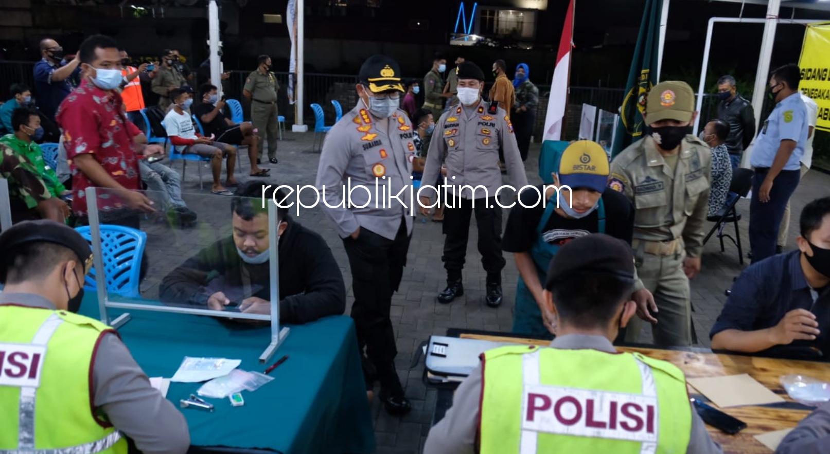 SIDANG DI TEMPAT - Sebanyak 53 pelanggar protokol kesehatan disidang di tempat di JL KH Ali Masud Desa Pagerwojo, Kecamatan Buduran, Sidoarjo untuk memberi efek jerah bagi warga, Jumat (18/12/2020) malam. 