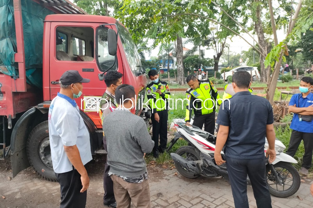 OLAH TKP - Sejumlah petugas Unit Laka, Satuan Lantas, Polresta Sidoarjo menggelar olah TKP pengendara motor yang tertabrak truk di JL Raya Waru, Sidoarjo hingga menyebabkan korban tewas di TKP, Senin (20/12/2021).