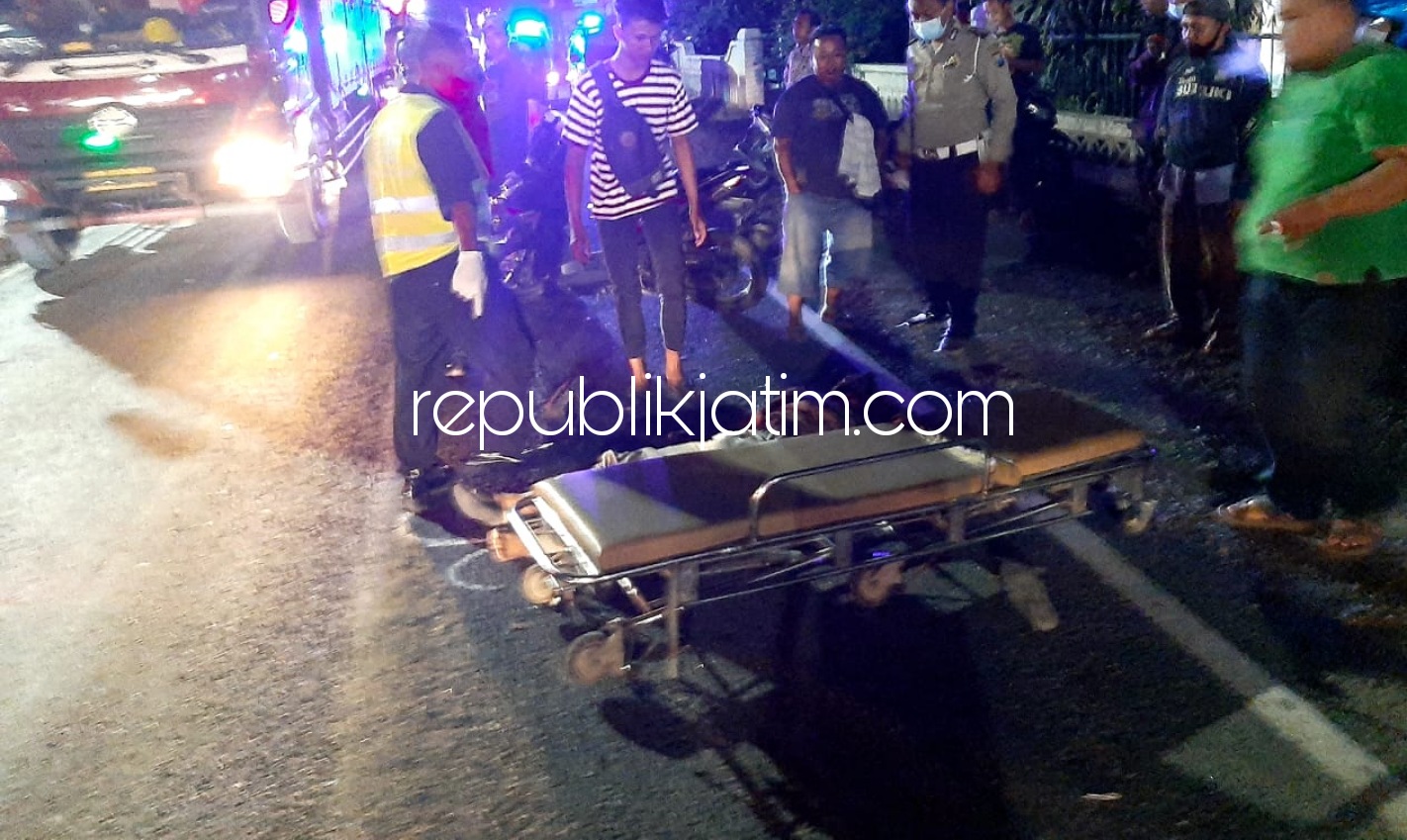 EVAKUASI - Pengendara motor tewas menabrak truk tronton di JL Raya Bakalanwringinpitu, Kecamatan Balongbendo, Sidoarjo dievakuasi petugas dan warga untuk dibawa ke rumah sakit terdekat, Rabu (23/12/2020) malam.