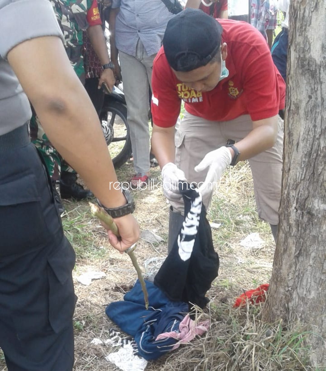BARANG BUKTI - Petugas Inafis Polresta Sidoarjo mengamankan barang bukti pakaian korban di lokasi sekitar lokasi penemuan mayat perempuan telanjang di Lingkar Timur, Sidoarjo, Selasa (31/12/2019).