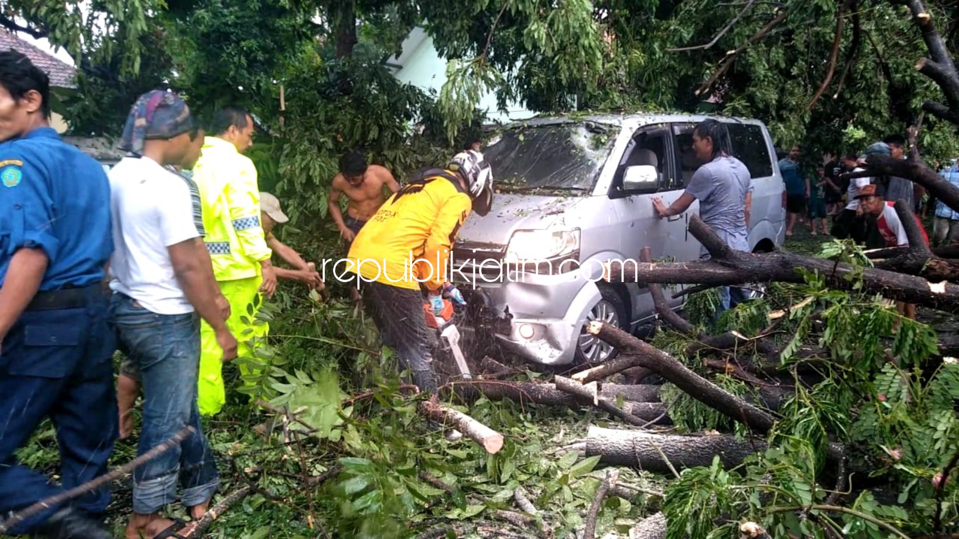 TERTIMPA - Sebuah mobil APV tertimpa pohon tumbang saat melintas di JL Raya Desa Singopadu, Kecamatan Tulangan, Sidoarjo bersamaan hujan deras, Selasa (31/12/2019) sore. 