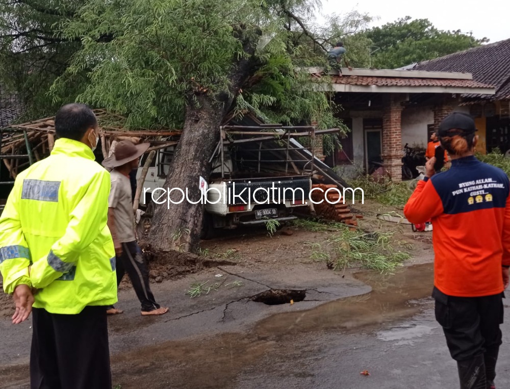 TUMBANG - Pohon asem di depan rumah Nursalim warga Dusun Alan, Desa Gundik, Kecamatan Slahung, Ponorogo roboh dan menimpa mobil serta rumah milik Nursalim dan Parno, Rabu (13/01/2022).
