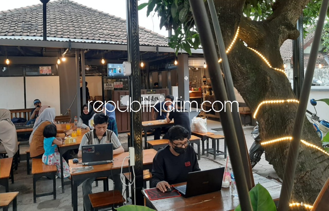 ALA KAFE - Salah satu pengunjung menikmati makanan dan minuman sekaligus membawa laptop dengan asik nikmati kecepatan wifi 100 MBPS di Warkop In Dusun Sidomukti, Desa Kraton, Kecamatan Krian, Sidoarjo, Sabtu (15/01/2022) sore. 