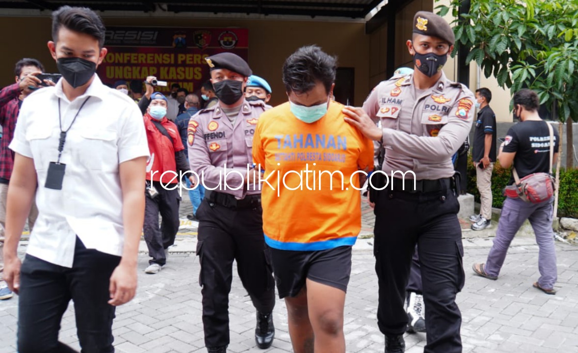 GELANDANG - Salah seroang tersangka pencurian motor, DMA (21) digelandang petugas Satuan Reskrim Polresta Sidoarjo beserta barang bukti hasil curiannya, Senin (17/01/2022). 