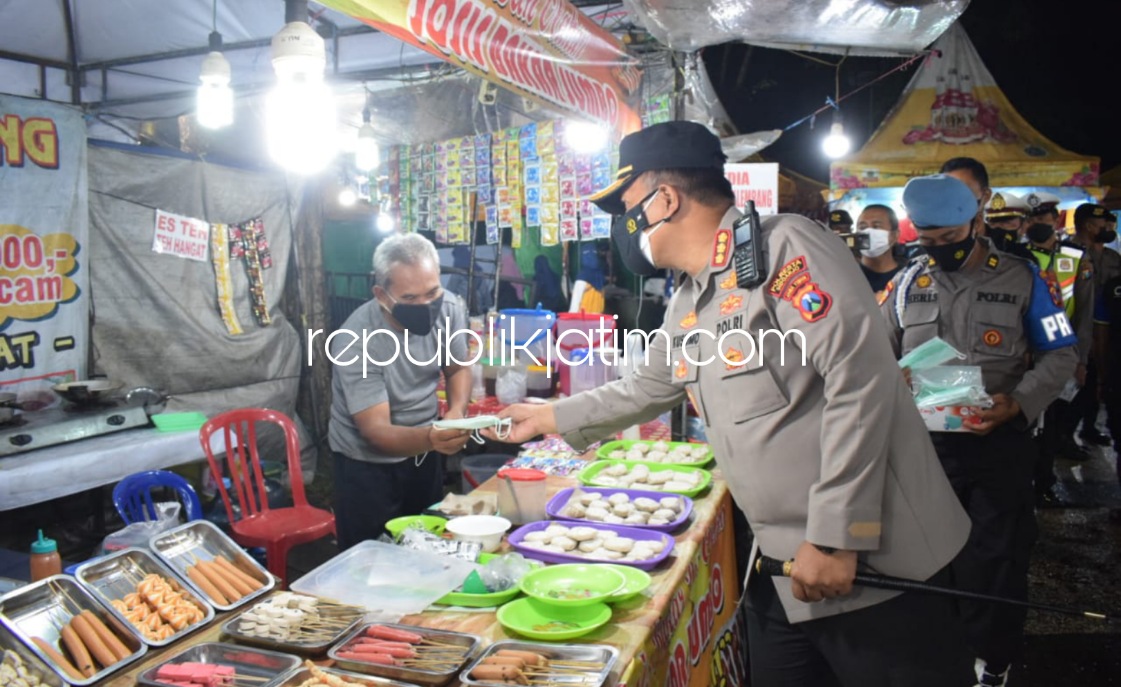BAGI - Kapolresta Sidoarjo Komisaris Besar Polisi Kusumo Wahyu Bintoro turun langsung memimpin patroli skala besar, guna menekan laju penyebaran Covid-19 dengan membagikan masker ke pedagang kaki lima di Gading Fajar, Sidoarjo, Jumat (12/02/2022) malam.