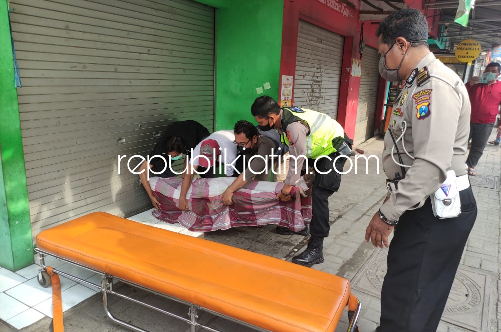 EVAKUASI - Sejumlah petugas mengevakuasi jenazah pria tanpa identitas yang meninggal di depan ruko JL Kemendung Indah, Desa Bringinbendo, Kecamatan Taman, Sidoarjo, Jumat (18/03/2022).