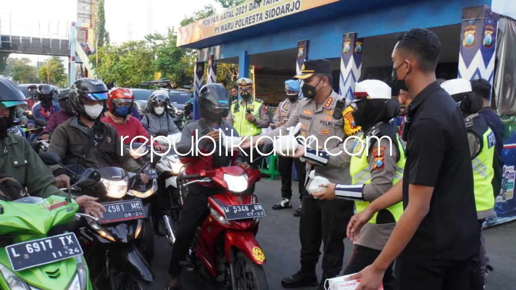 TAKJIL - Kapolresta Sidoarjo Kombes Pol Kusumo Wahyu Bintoro mengecek gerai vaksin booster yang menyediakan 300 dosis vaksin Astrazeneca sekaligus membagi-bagikan takjil ke para pengendara di Pos Polisi Waru, Sidoarjo, Senin (11/04/2022) sore.