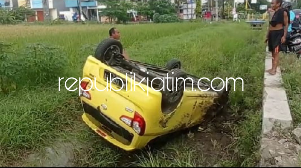 TERBALIK - Sebuah mobil Daihatsu Ayla bernopol W 1438 XI yang dikendarai Susiati (42) warga Perum Permata Megahasri, Desa Sidokepung, Kecamatan Buduran terbalik di persawahan JL Raya Ksatrian (Sidokepung - Sarirogo), Selasa (26/04/2022).