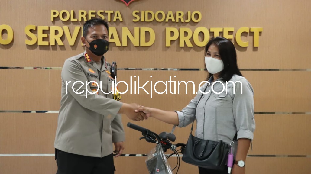 HADIAH - Kapolresta Sidoarjo, Kombes Pol Kusumo Wahyu Bintoro menyerahkan sepeda ke Farida warga Segoropuro, Kecamatan Rejoso, Pasuruan yang hendak pergi ke Surabaya turun di Terminal Bungurasih, Waru ikut vaksin dan menerima hadiah, Jumat (29/04/2022). 
