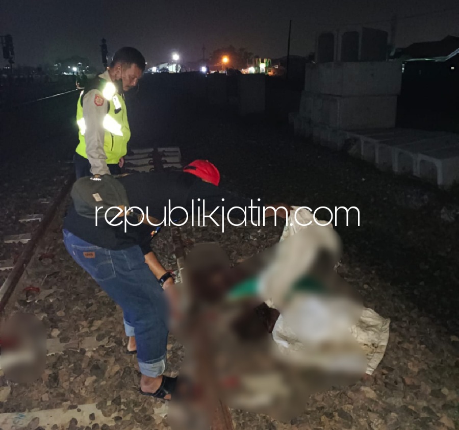 EVAKUASI - Sejumlah petugas dan warga mengevakuasi pria tanpa identitas yang tertabrak KA Wijaya Kusuma jurusan Cilacap ke Surabaya di Krajan Stasiun, Kelurahan/Kecamatan Krian, Sidoarjo, Minggu (19/06/2022) malam.