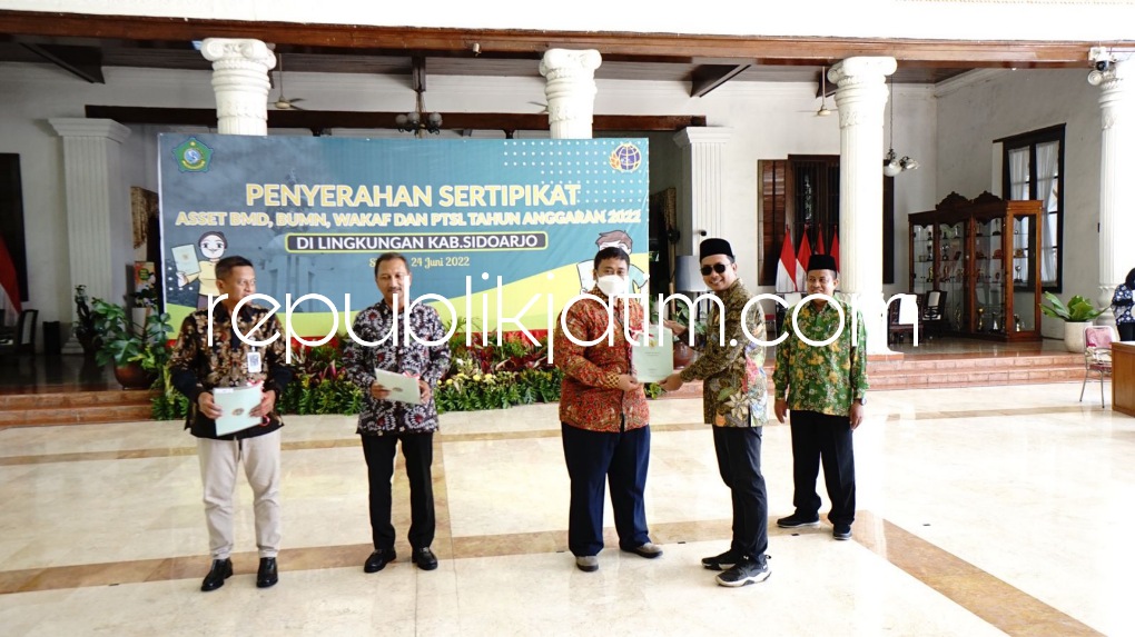 SERAHKAN - Bupati Sidoarjo Ahmad Muhdlor Ali menyerahkan sertifikat Aset Badan Milik Daerah (BMD), Aset Badan Milik Nasional (BMN), wakaf dan PTSL Tahun 2022 di Pendopo Delta Wibawa, Jumat (24/06/2022).