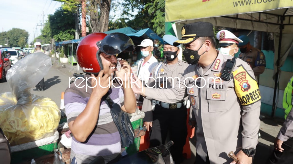 BAGIKAN - Kapolresta Sidoarjo Kombes Pol Kusumo Wahyu Bintoro membagikan helem dan menyediakan vaksinasi gratis saat razia di Pos Polisi Medaeng, Kecamatan Waru, Sidoarjo, Jumat (24/06/2022).