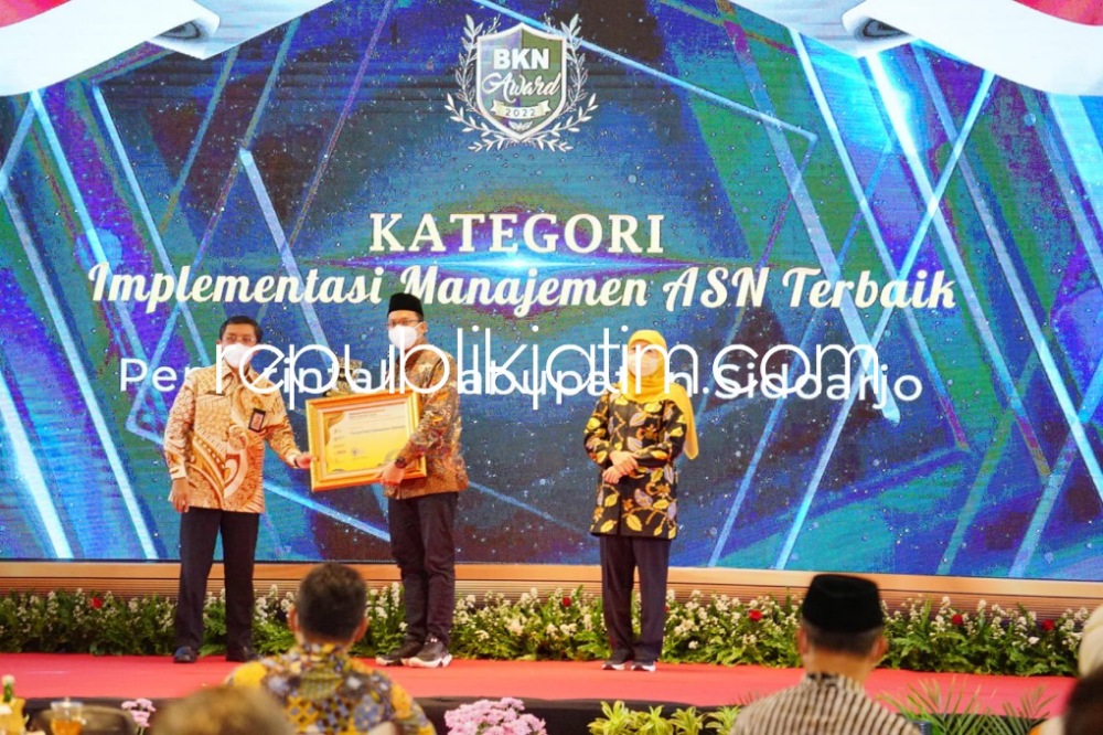 BORONG - Bupati Sidoarjo Ahmad Muhdlor Ali memborong tiga penghargaan sekaligus dari BKN RI yang diberikan Wakil Kepala BKN RI Supranawa Yusuf didampingi Gubernur Jawa Timur Khofifah Indar Parawansa di Hall Golden Tulip Hotel Batu, Rabu (10/08/2022).