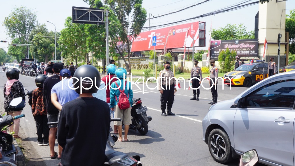 DIHENTIKAN - Tepat pukul 10.17 WIB peringatan detik-detik proklamasi, pengendara dan masyarakat yang melintas di JL Raya Cemengkalang, Kecamatan Sidoarjo tepat di depan Polresta Sidoarjo diberhentikan Polisi, Rabu (17/08/2022).