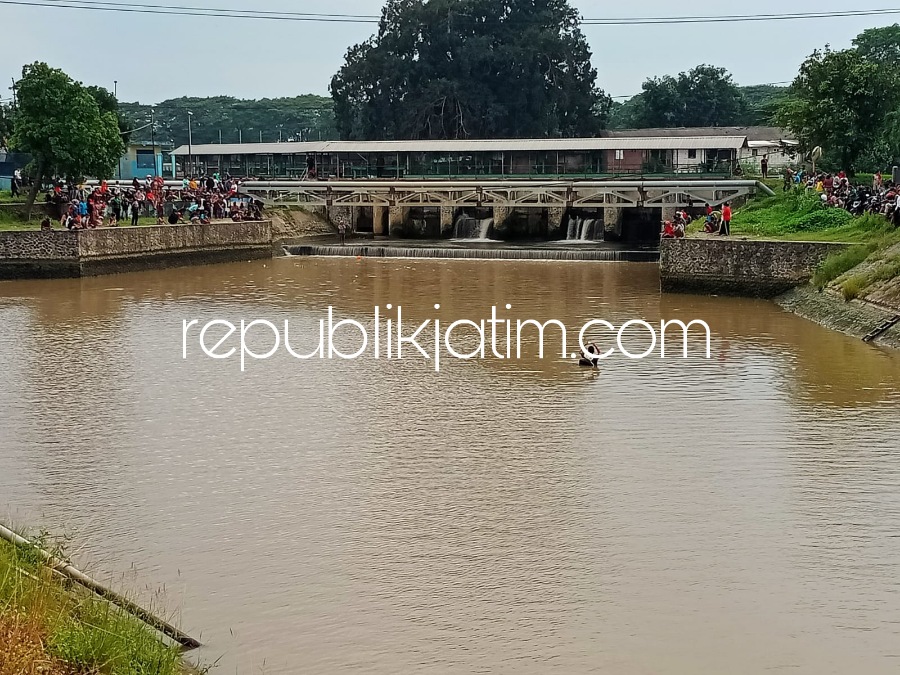 PENCARIAN - Sejumlah Petugas gabungan Polsek Tarik dan tim SAR bersama warga sekitar mencari korban Leo Pradana yang tenggelam di Sungai Kanal Mangatan (Rolak Songo), Desa Mliriprowo, Kecamatan Tarik, Sidoarjo, Rabu (28/12/2022) petang.