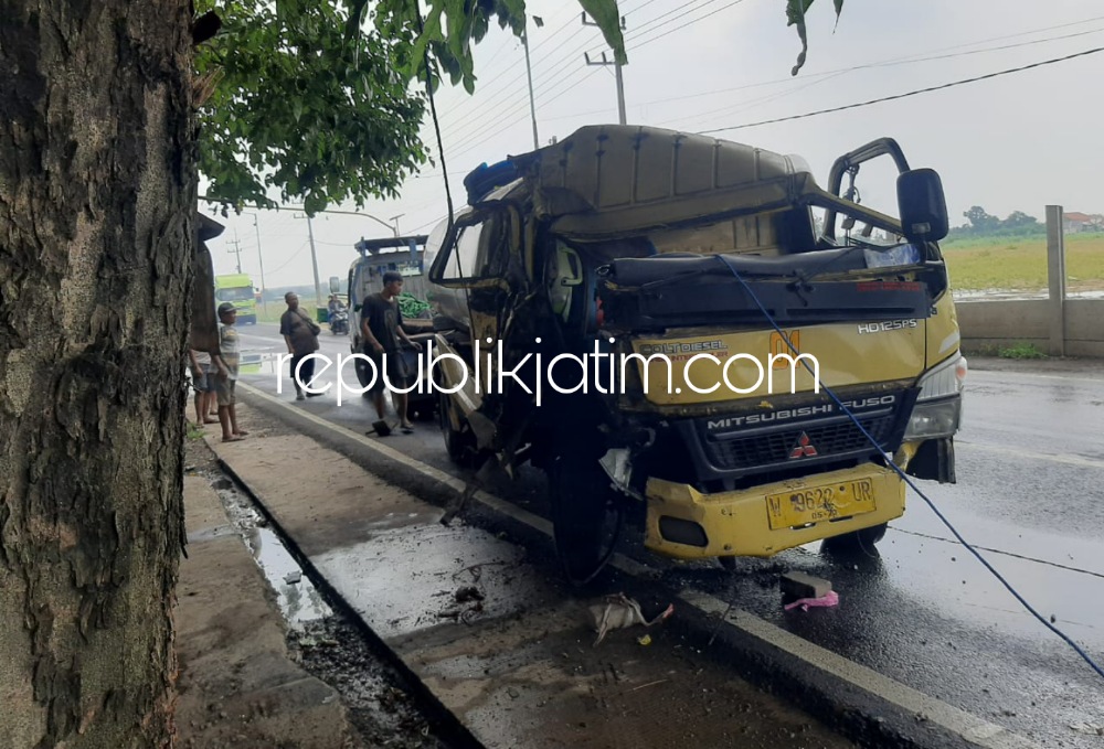 RINGSEK - Seorang petugas Lantas menunjukkan kondisi truk yang ringsek usai mengalami kecelakaan di dekat Balai Desa Kemangsen, Kecamatan Balongbendo, Sidoarjo, Rabu (25/01/2023). 