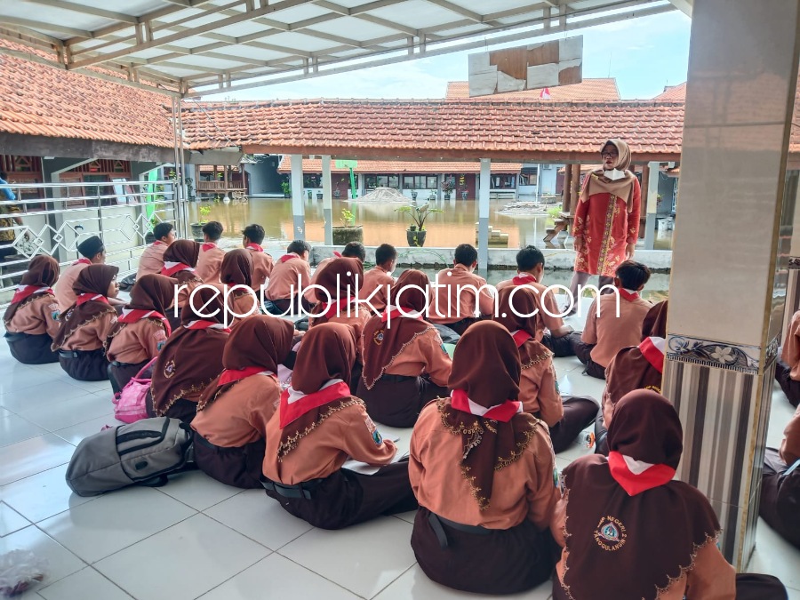 DIUNGSIKAN - Para siswa SMPN 2 Tanggulangin, Sidoarjo diungsikan ke masjid sekolah lantaran 7 ruang kelasnya masih dalam kondisi tergenang air banjir, Sabtu (11/02/2023).