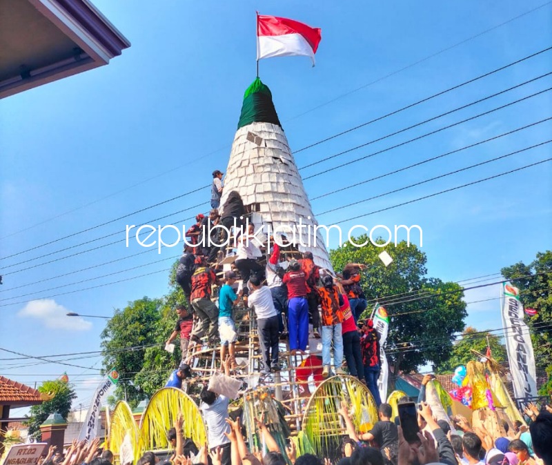 REBUTAN - Ratusan warga rebutan Gunungan Tempe Raksasa yang ada di halaman Balai Desa Sedenganmijen, Kecamatan Krian, Sidoarjo sebagai penutup acara ruwah desa selama 3 hari terakhir, Minggu (19/03/2023).