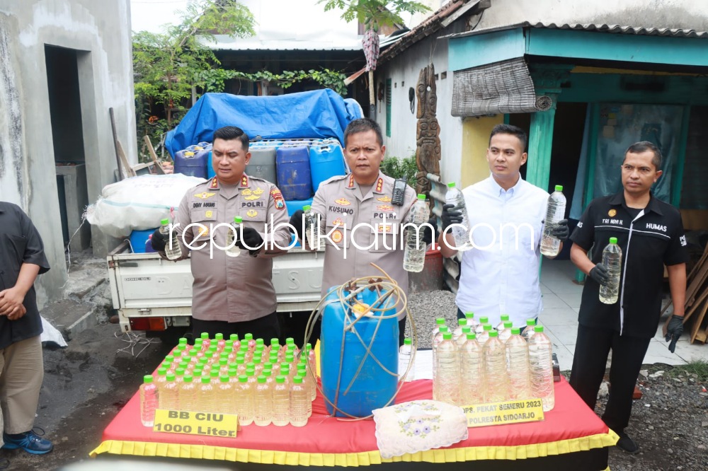 MIRAS - Kapolresta Sidoarjo Kombes Pol Kusumo Wahyu Bintoro menunjukkan 1.000 liter miras jenis arak jowo atau ciu yang diamankan dari salah satu rumah di Desa Sugihwaras, Kecamatan Candi, Sidoarjo, Selasa (28/03/2023).
