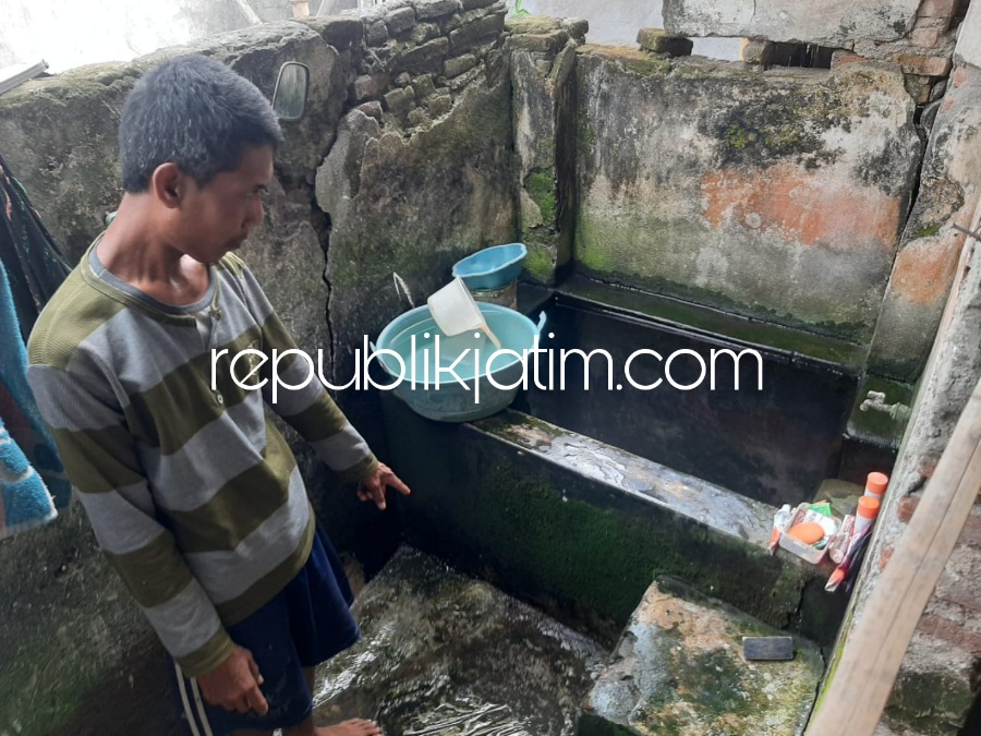 JAMBAN - Suwito warga Dusun Juglang, Desa Singogalih, Kecamatan Tarik menunjukkan kamar mandi tanpa WC (jamban) dan fasilitator program DAK Sanitasi Dinas P2CKTR Pemkab Sidoarjo, Agus Susilo saat sosialisasi di balai desa setempat, Senin (05/06/2023).