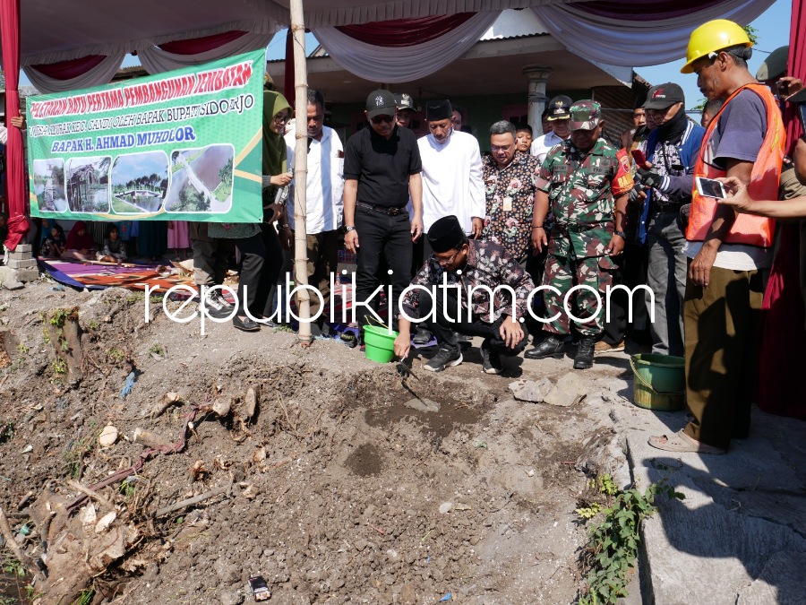 PERTAMA - Bupati Sidoarjo, Ahmad Muhdlor Ali meletakkan batu pertama tanda dimulainya pembangunan jembatan Shiratal Mustaqim yang dikerjakan PT Mulyo Joyo Makmur dengan nilai Rp 1,4 miliar di Desa Klurak, Kecamatan Candi, Sidoarjo, Jumat (23/06/2023). 